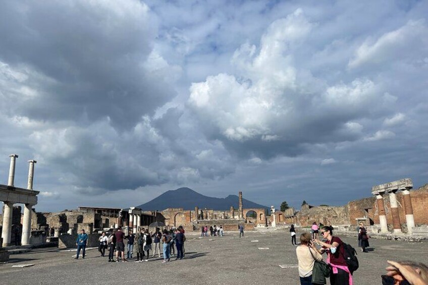 Ruinas antiguas con columnas y un volcán al fondo. 2
