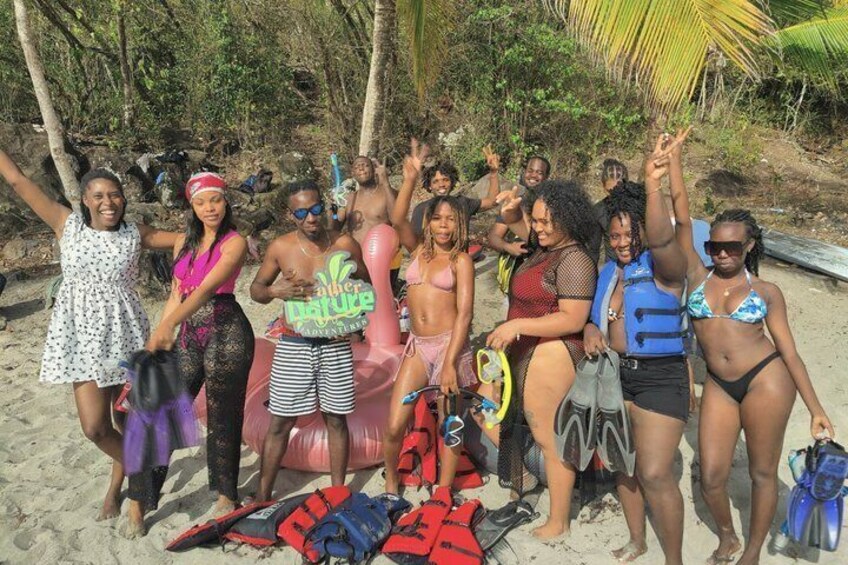A group of people on a beach with surfboards and life vests. 2