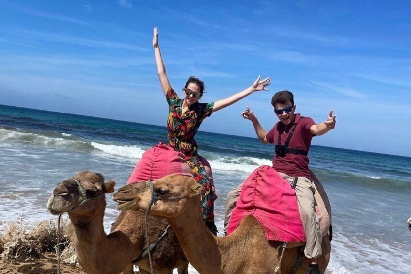 Two people on camels by the sea. 4