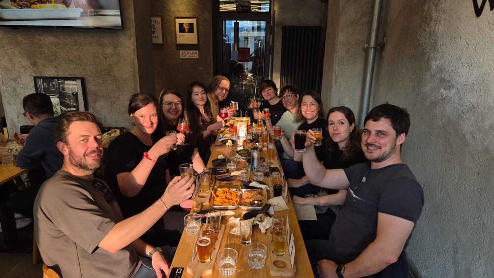 A group of people toasting at a wooden table in a restaurant with a rustic interior. 5
