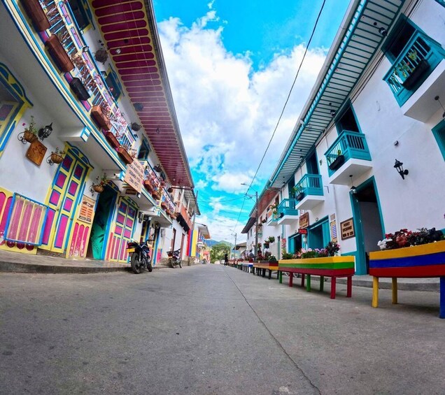 A colorful street with buildings, a motorcycle, and a clear sky. 4