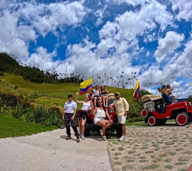 A group of people on a red jeepney, a tropical landscape with palm trees, and a clear blue sky with clouds. 3