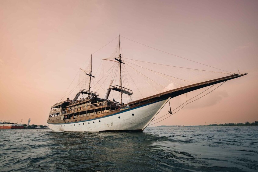 A large sailing ship with multiple masts and a wooden deck, floating on calm waters. 1