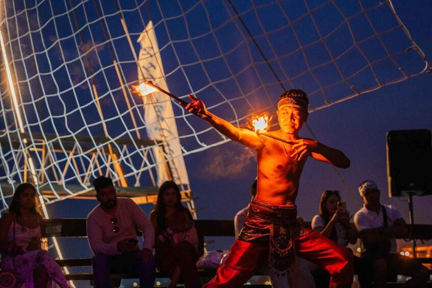 A person performing with fire props in a nighttime setting. 5