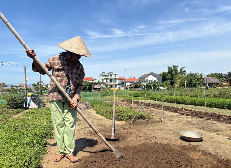 A person working in a field with a hoe, wearing a conical hat, and a plaid shirt. 3