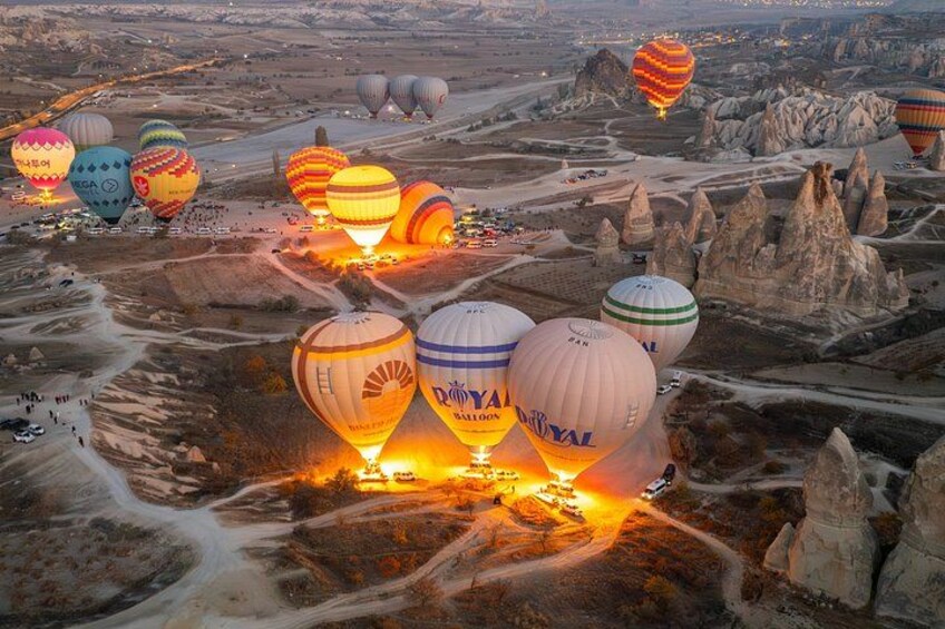 Een luchtballonfestival met meerdere ballonnen boven een ruig landschap. 1