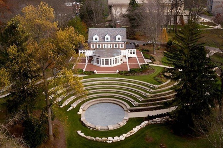 A large house with a circular driveway and a central water feature. 3