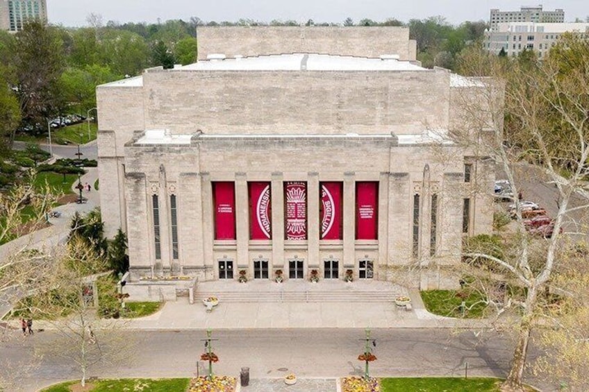 A large building with a central entrance and red banners. 5