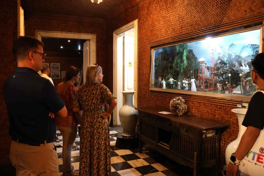 A room with a checkered floor, a large aquarium, and a brick wall. 5