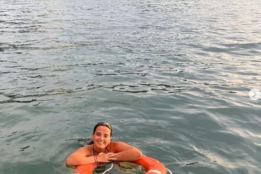 A person in a body of water with ripples and a floating object. 2