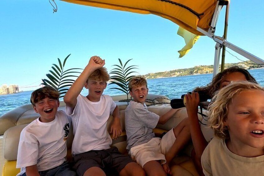 A group of people on a boat with a clear view of the water and distant land. 4