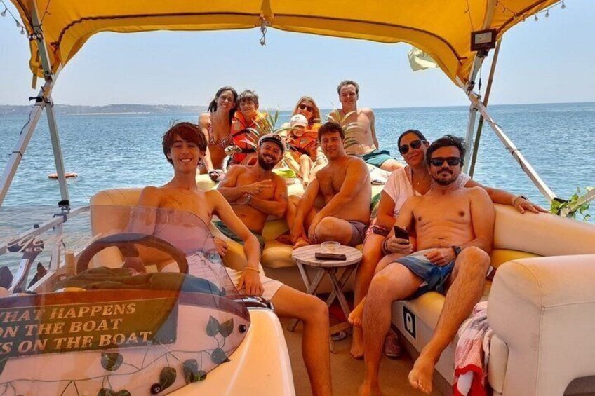A group of people on a boat with a canopy, surrounded by water. 1