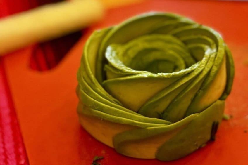 A green artichoke on a red surface. 1