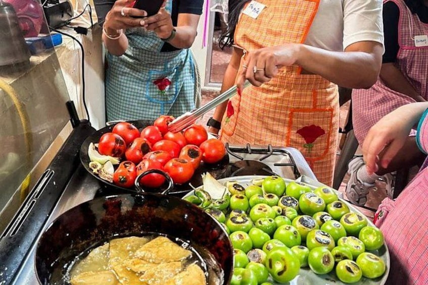 A food stall with grilled tomatoes and green apples. 5