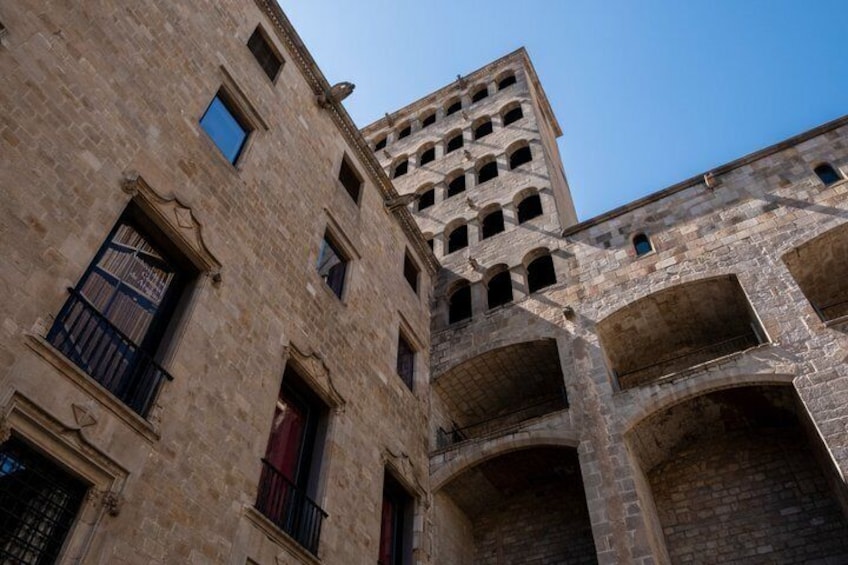 Un edificio histórico con ventanas de arco y una torre. 5