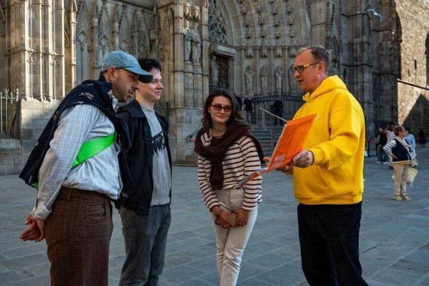 Un groupe de personnes se tient devant un grand bâtiment orné, de style gothique. 1