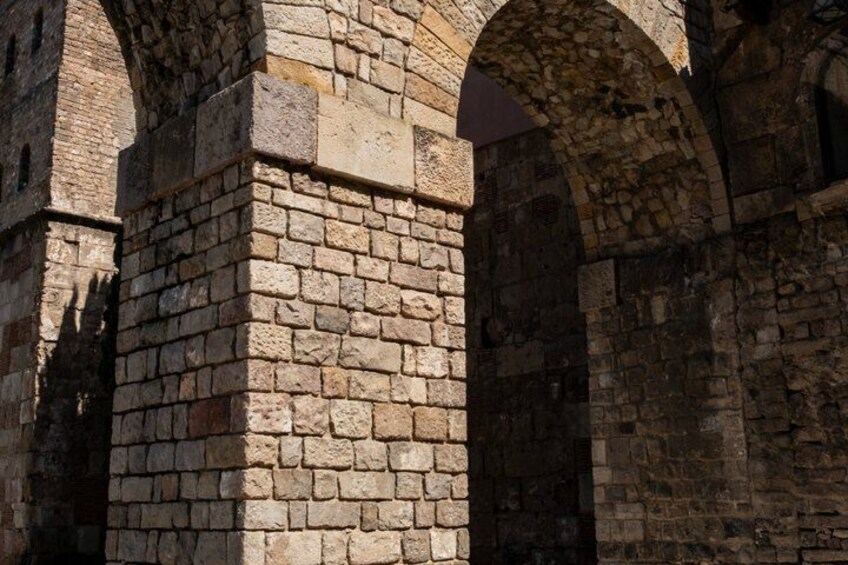 Une arche en pierre surmontée d’un mur de briques. 3