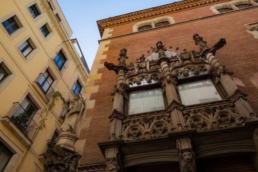 Un bâtiment doté d’éléments architecturaux raffinés, notamment des statues et un balcon décoratif. 2