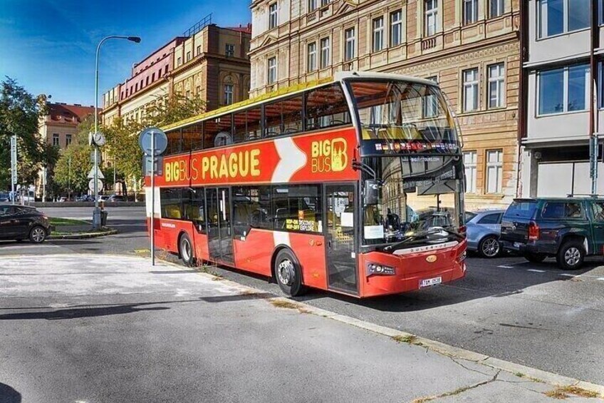 A red double-decker bus with 'BIG BUS PRAGUE' on its side, parked on a city street. 1