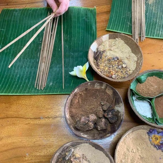 A table with various natural ingredients and tools, possibly for a traditional cooking or crafting activity. 2