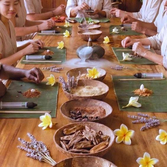 A group of people participating in a traditional tea ceremony with natural elements and flowers. 1