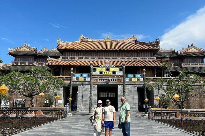 Een traditioneel Chinees gebouw met versierde architectuur, een geplaveid pad en een helderblauwe lucht. 4