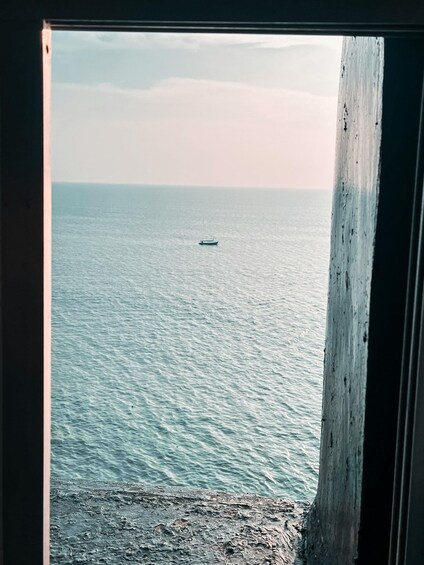 A calm sea with a small boat in the distance. 3