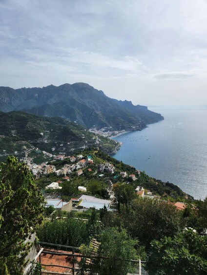 A coastal town nestled between mountains, with terraced fields and a clear view of the sea. 1