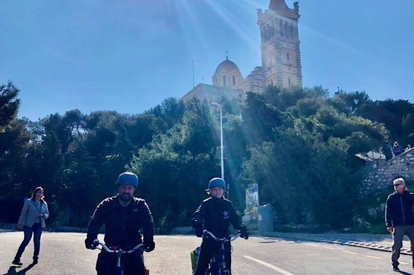 Personas montando bicicletas sobre una carretera con una torre histórica al fondo. 2