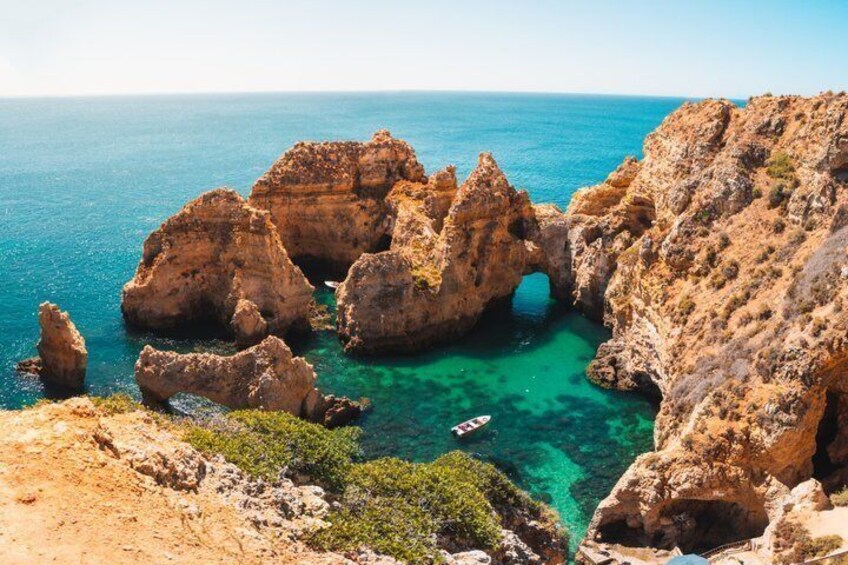 A coastal landscape with rocky formations and clear blue waters. 5