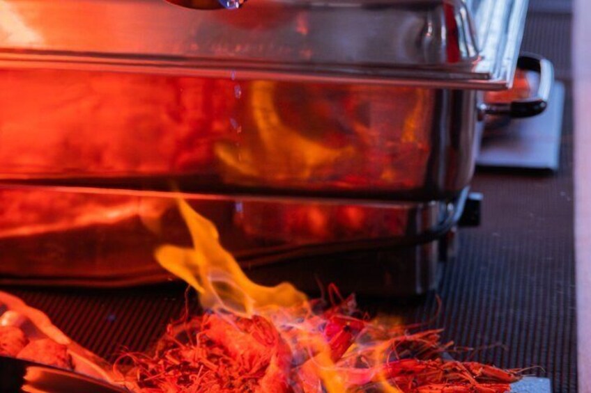 A barbecue grill with visible flames and a glass container on it. 3