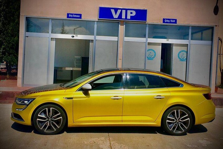 En gul bil parkeret foran en bygning med et skilt, der angiver VIP-indgang. 4