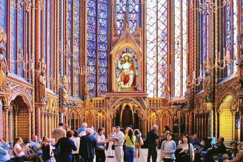 Interno di una cattedrale con vetrate colorate, un altare centrale e una congregazione di persone. 3
