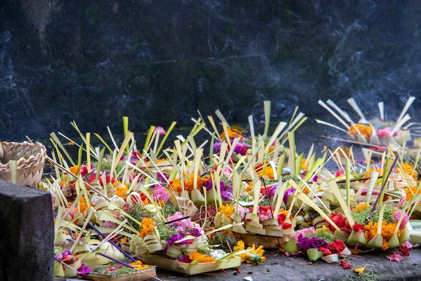 An altar with incense sticks, flowers, and offerings. 1