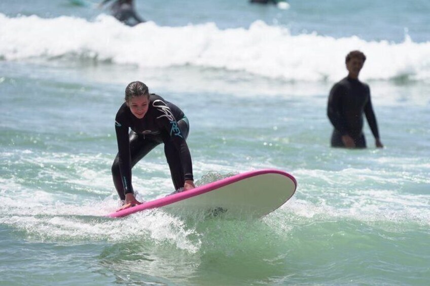 A person surfing on a pink board in the ocean. 3