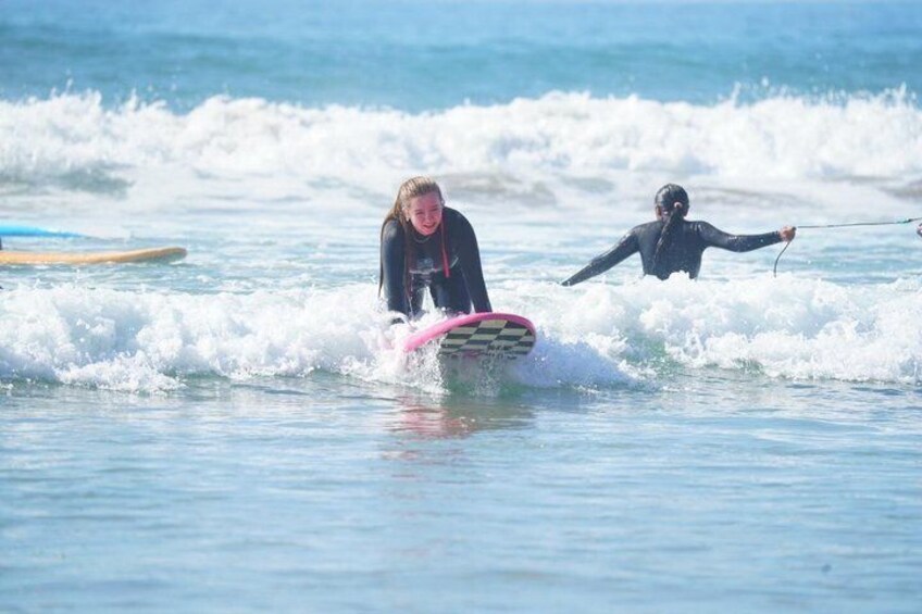 Two people surfing on a wave with surfboards. 1