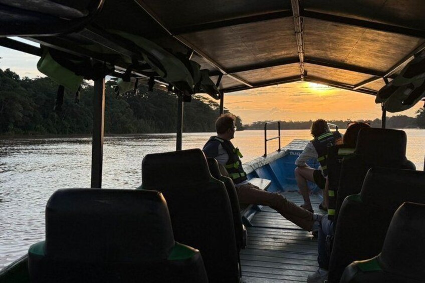 A boat with people on a dock during sunset. 1