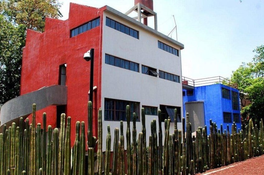A modern building with a red and white facade, surrounded by a cactus garden. 5