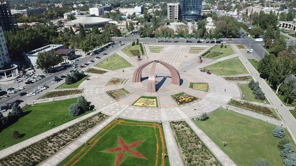 A circular plaza with a star-shaped flower bed, surrounded by roads and buildings. 3