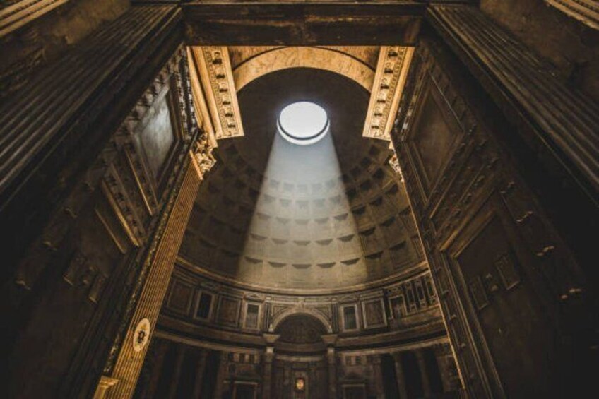 An interior with a dome ceiling, arched windows, and classical architectural details. 1