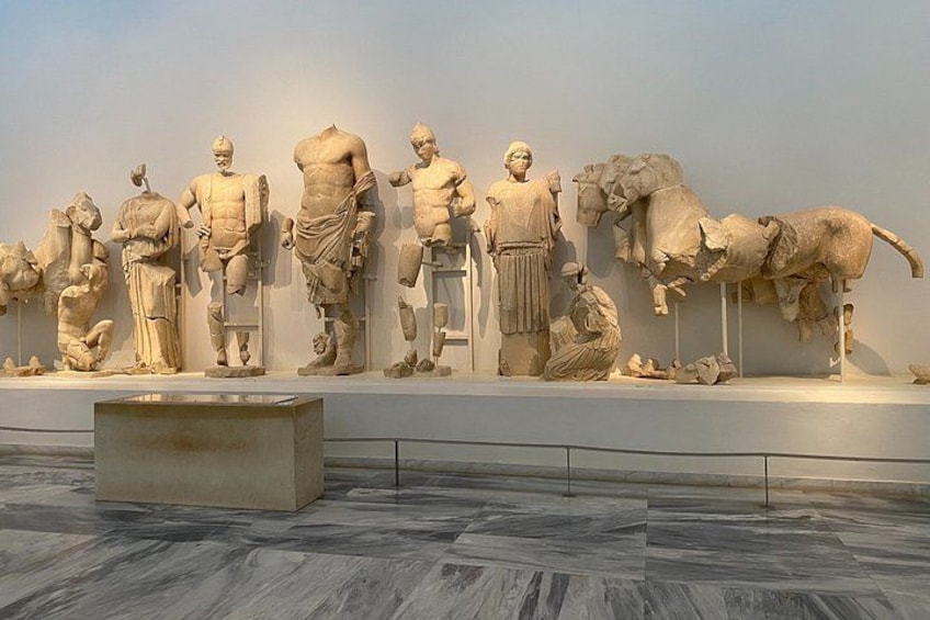 Una scultura marmorea raffigura un carro trainato da cavalli con cavalieri, esposta in un museo. 1
