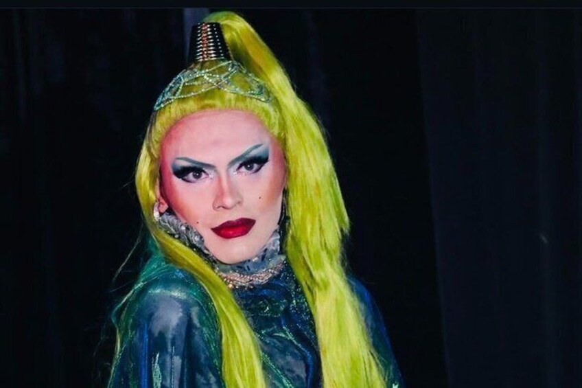 Una persona de cabello largo y rubio, vestida con un traje metálico y un tocado. 3