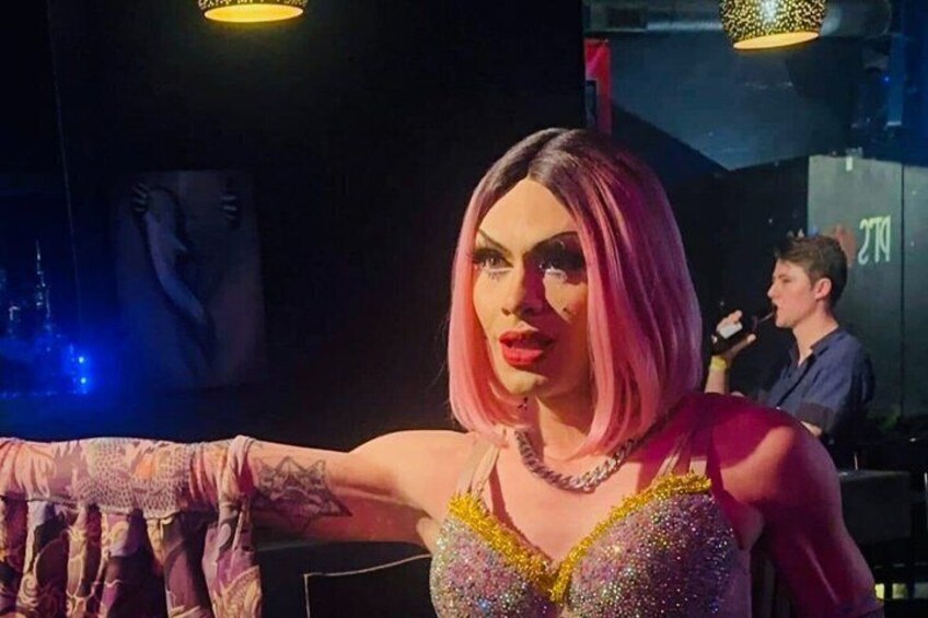 Una persona con un vestido brillante y un micrófono de fondo. 4