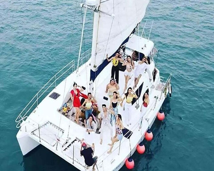 A sailboat with people on deck, surrounded by calm blue water. 2
