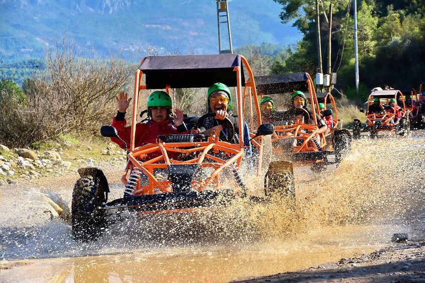 Off-road vehicles driving through a muddy terrain with splashes of water. 2