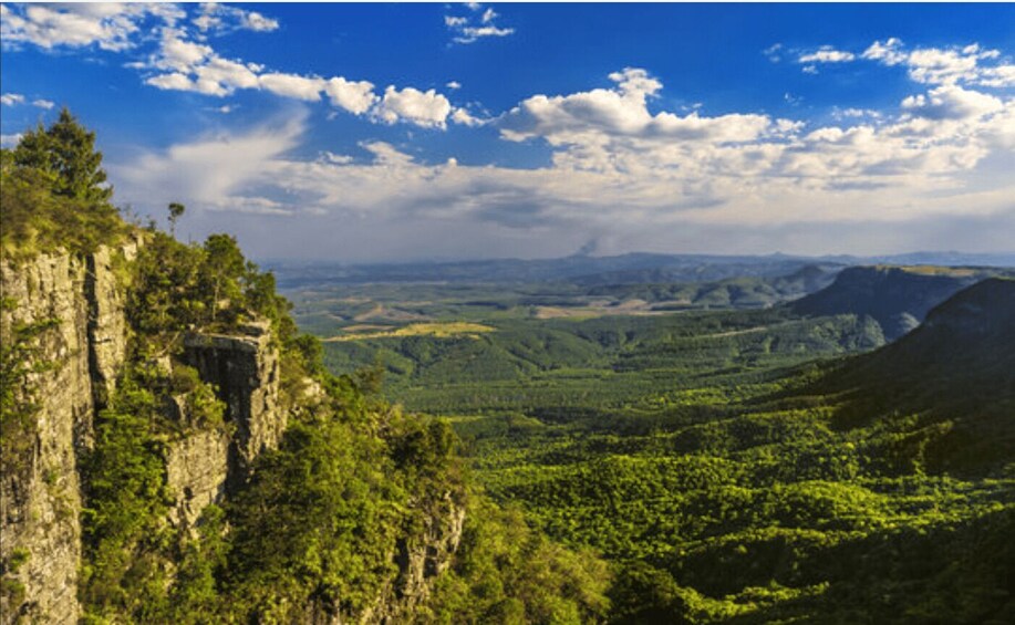 A mountainous landscape with dense forests and a clear sky. 5