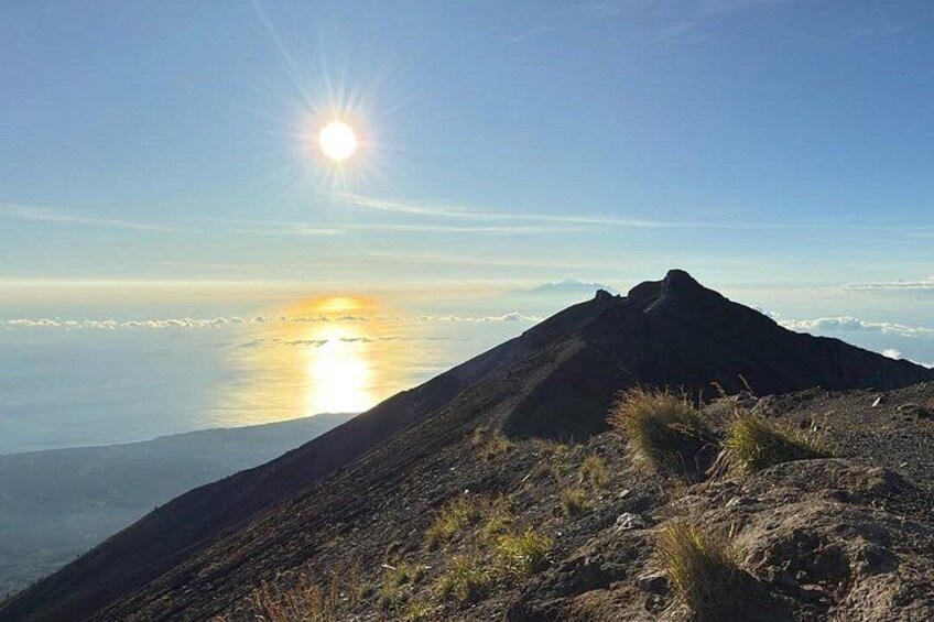 Un paisaje montañoso con cielo despejado y el sol ocultándose o saliendo en el horizonte. 2