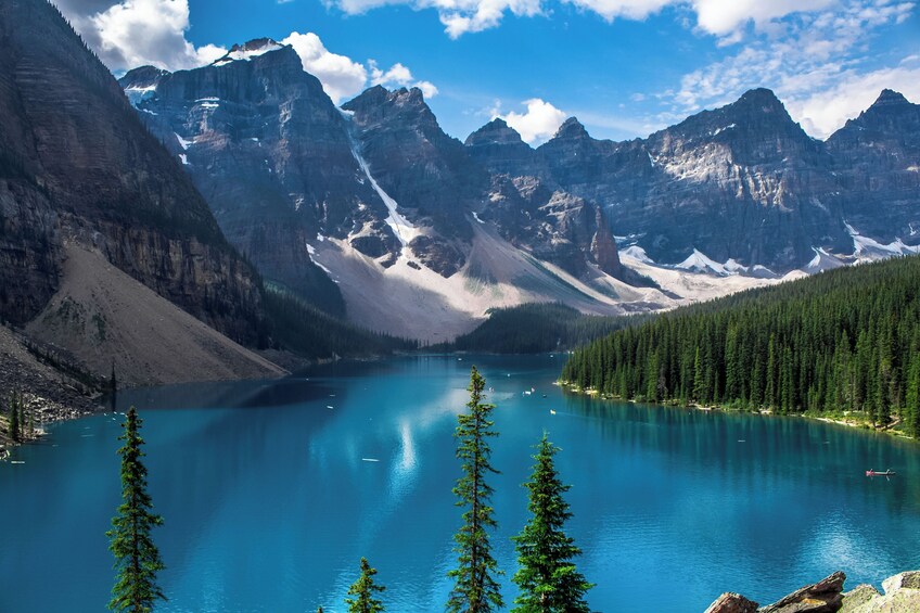 A mountain lake surrounded by forest and rugged peaks. 4
