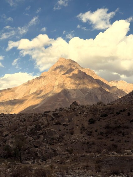 A mountain range with a clear sky and scattered clouds. 4