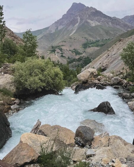 A river flowing through a rocky landscape with mountains in the background. 4